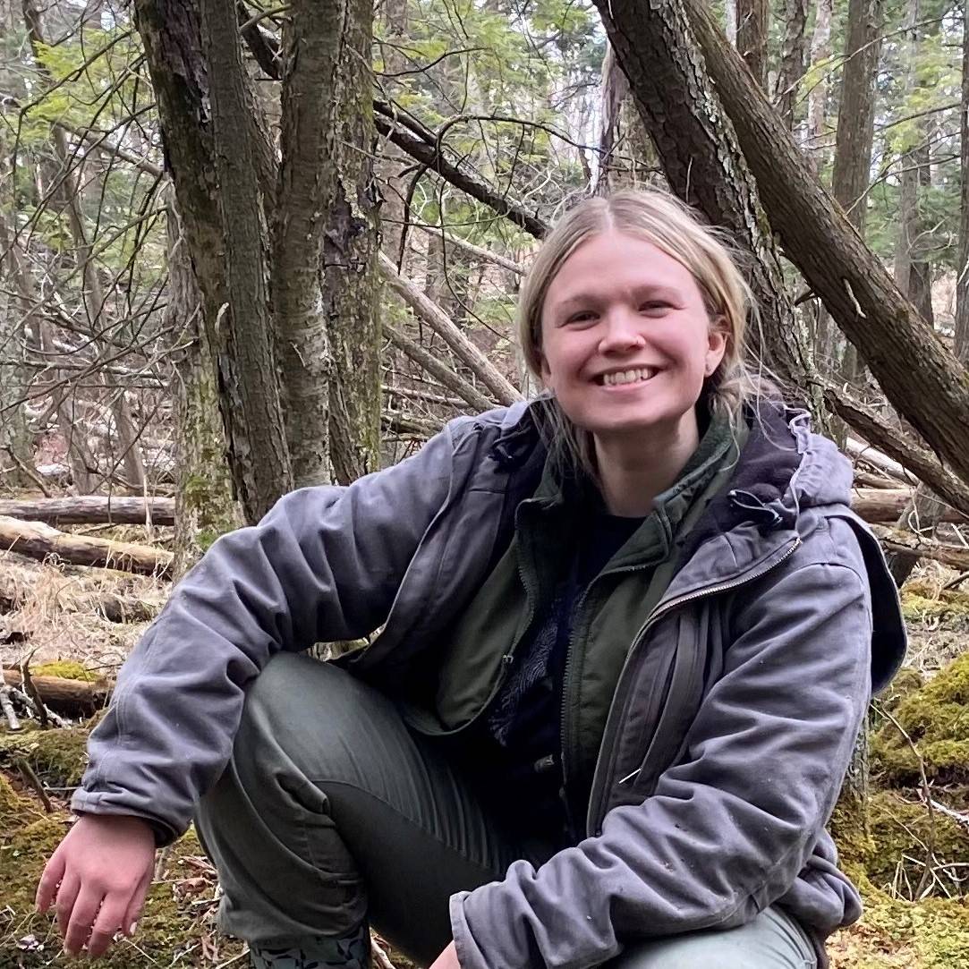 Keely Dunham conducting sitting in a forest.